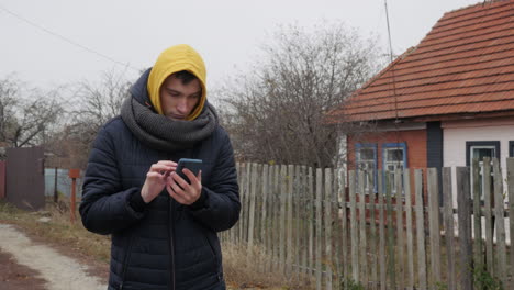 young man using smartphone in a rural area