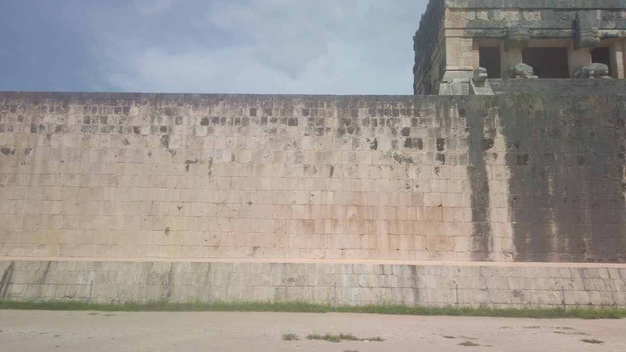 Gimbal wide panning shot of the court wall at the Great Mayan Ball Court in Chichen Itza, Mexico. 4K
