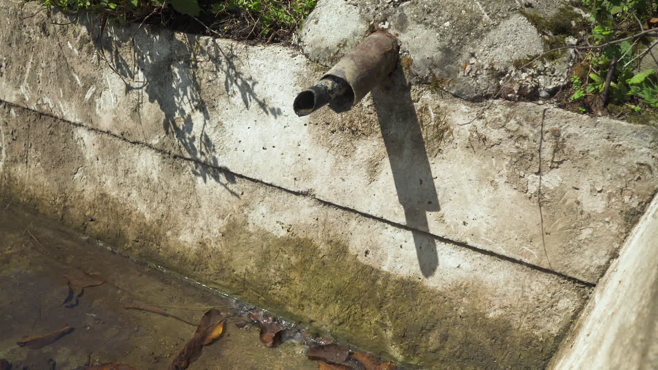 여름 더위에 천천히 물이 떨어지는 물동이 파이프