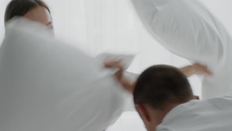 happy pillow fight in a cozy bedroom