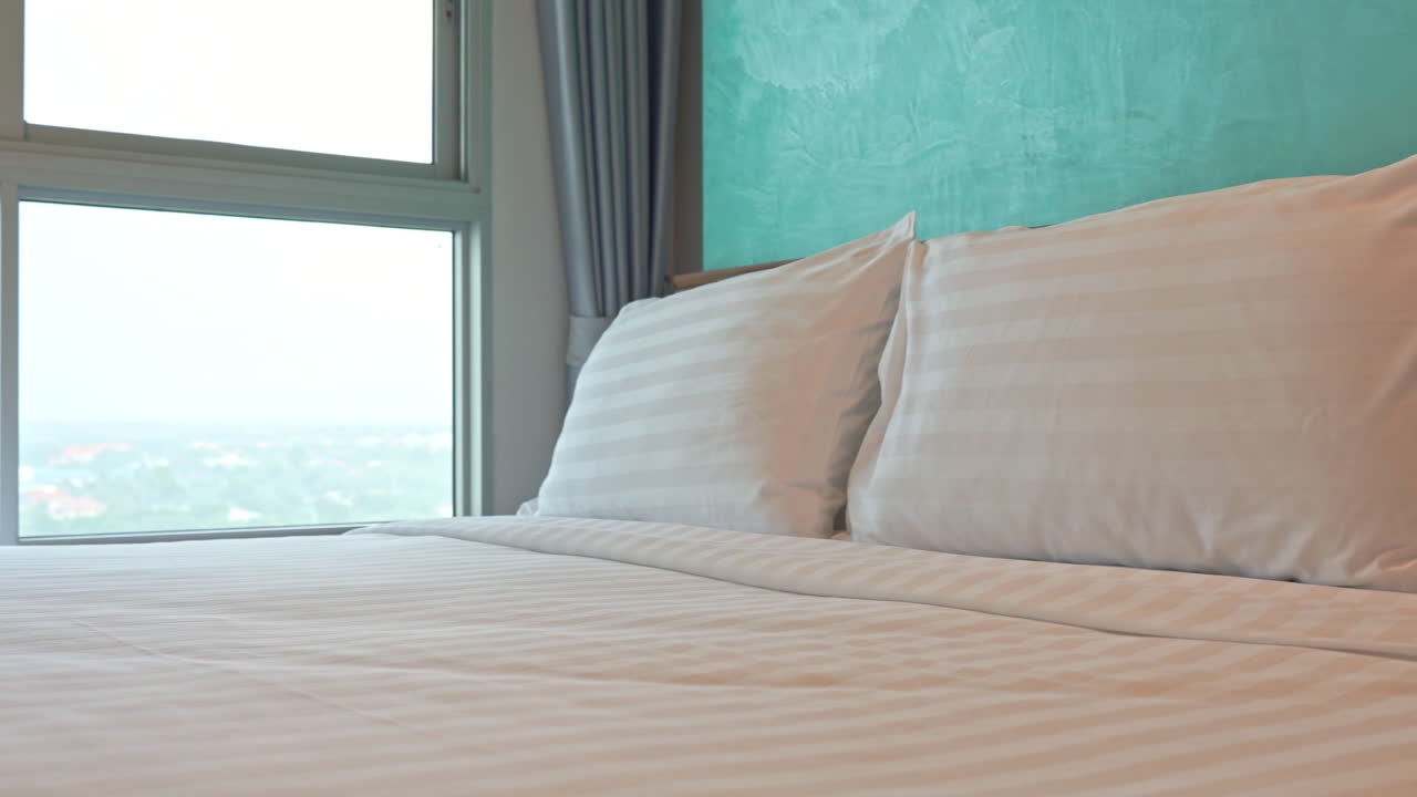 cama doble vacía en la habitación del hotel junto a la ventana con una vista impresionante