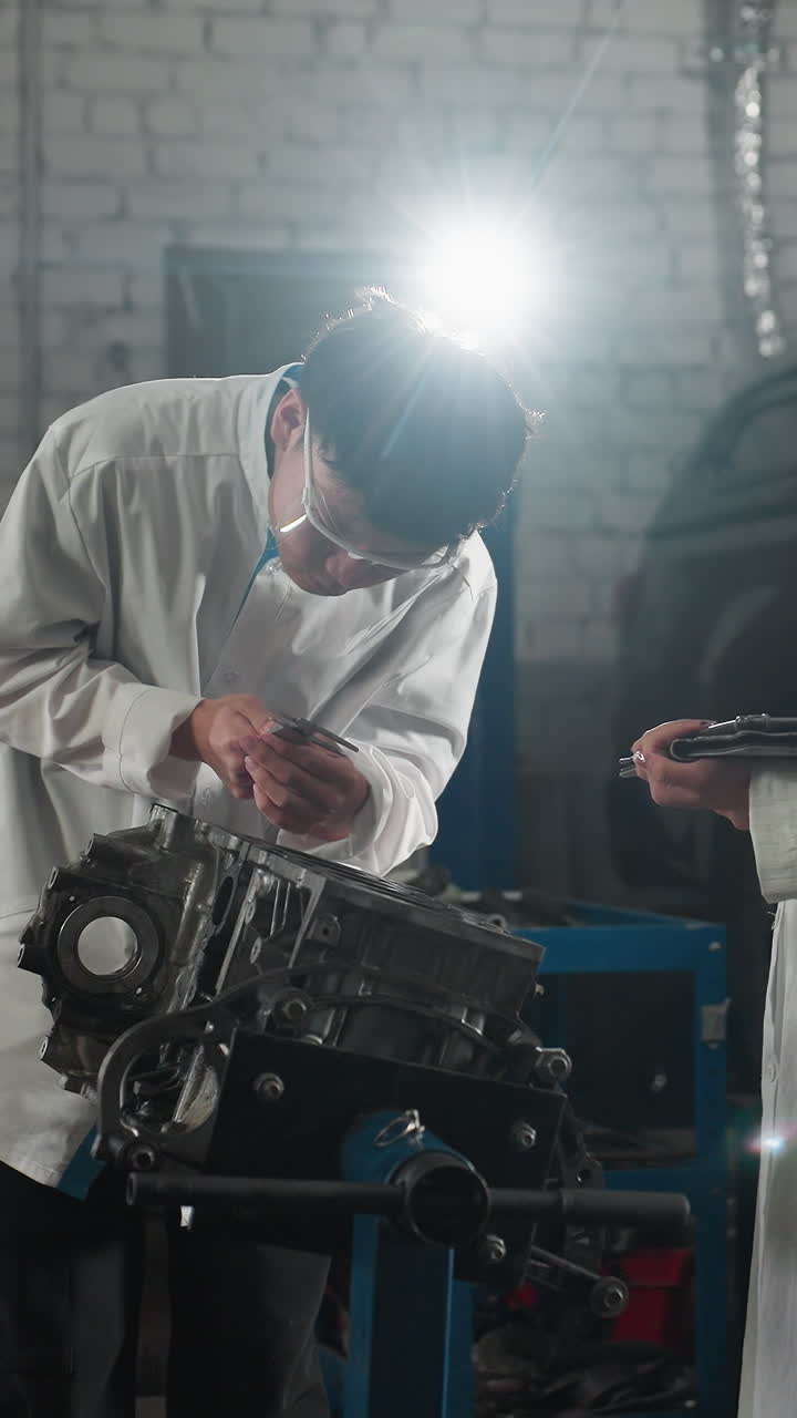 ingenieros en un taller automotriz, un niño midiendo un componente del motor con una pinza de vernier mientras una niña registra datos en una tableta, una luz brillante ilumina el espacio de trabajo, las herramientas, el coche estacionado en el fondo