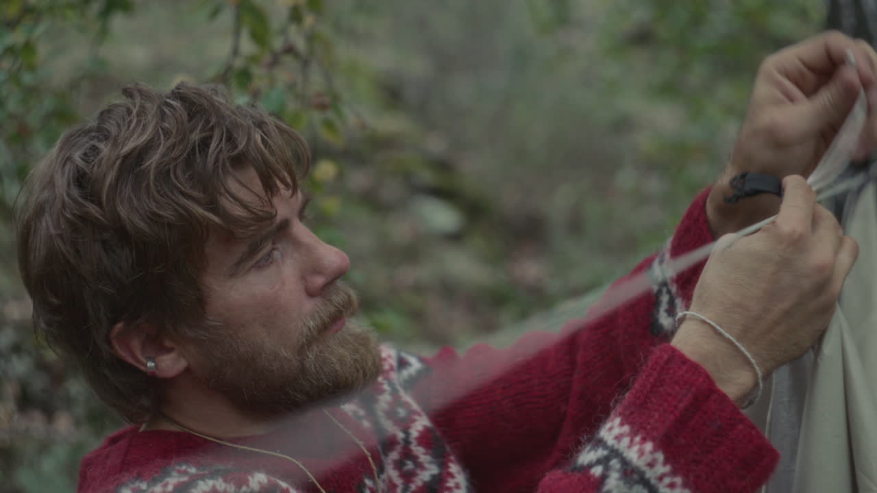 Man Assembling Tent Cord as Preparing Forest Campsite