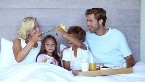 Familia-Sentada-En-La-Cama-Y-Desayunando-En-La-Cama