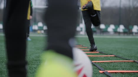 a children's football team trains at the stadium under the guidance of a coach. kids in sports uniforms practice ball exercises, improve technique, and develop teamwork on the green field