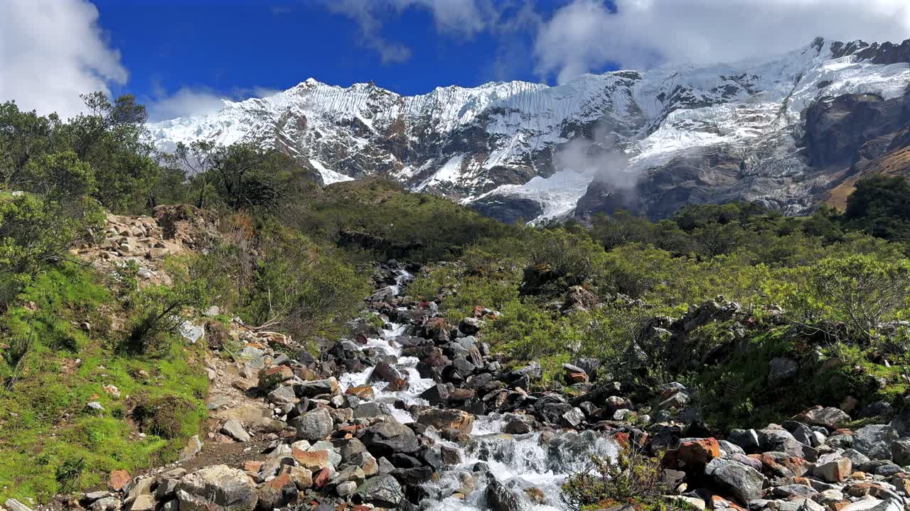 Ande peruviane Laguna Humantay sentiero del lago torrente roccioso fiume Perù Perú ghiacciaio Salkantay alta quota cime importanti cielo blu mattutino nuvole soleggiato provincia di Anta stagione secca delle piogge ripresa statica