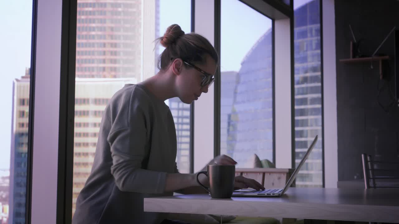 Giovane donna d'affari con gli occhiali lavora al laptop in ufficio. Bella donna con computer in un centro direzionale.