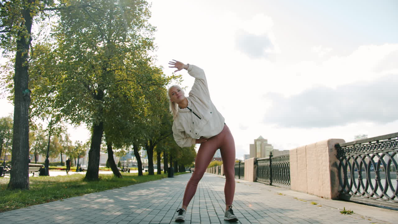 mujer estirándose en un parque de la ciudad