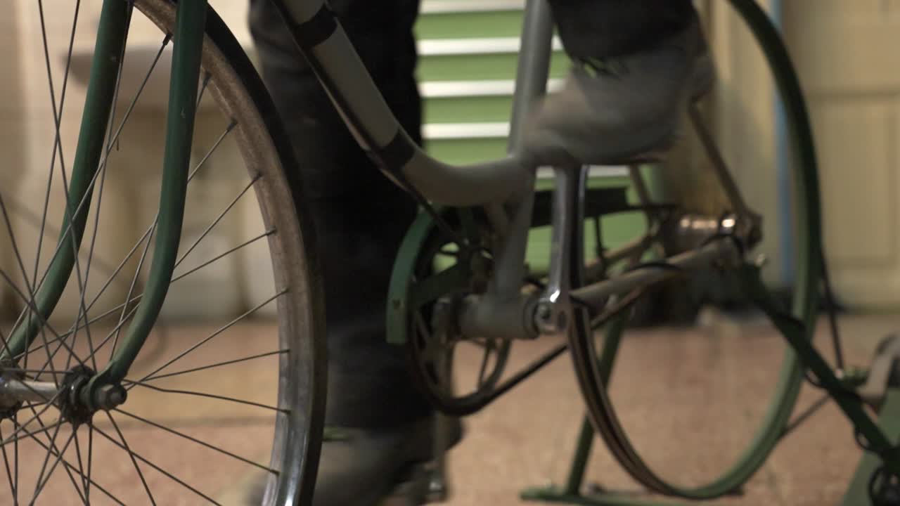 사람이 페달을 는 자전거의 아래 부분에 초점을 맞추고, 기어와 기계적 세부 사항을 보여줍니다.