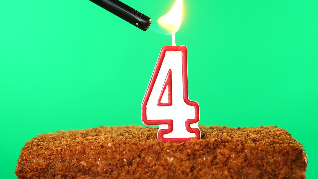 pastel con el número 4 vela encendida. llave de croma. pantalla verde. aislado