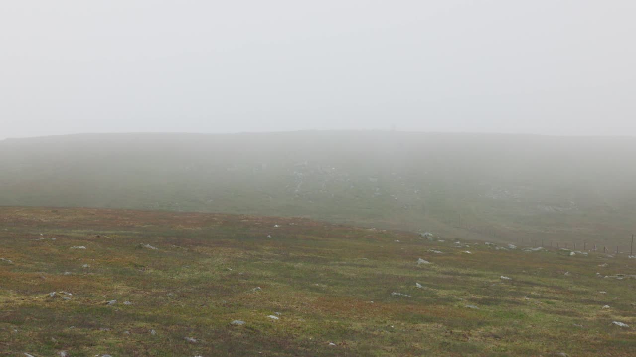 Static shot of misty rolling over the summit of Ben Chonzie in summer