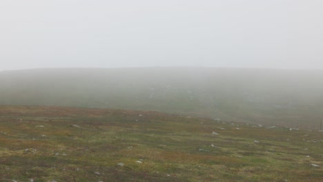 static shot of misty rolling over the summit of ben chonzie in summer