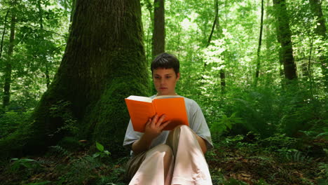 woman reading a book in a green forest