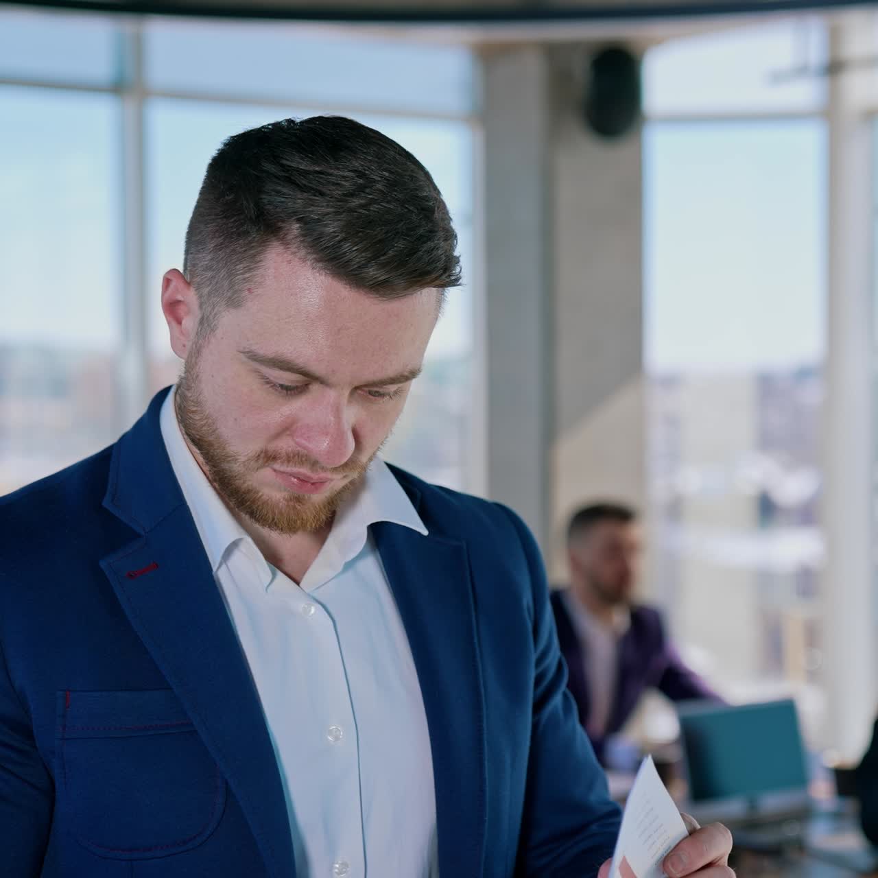 Businessmen working in office. Portrait of a handsome young entrepreneur thinking of new project in the modern business center on his colleagues background