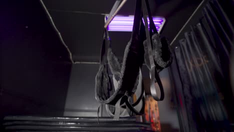 Bondage-swing-in-a-dark-room-with-purple-lights