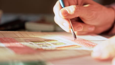 artist at work water colour painting, brush applying detail to the paper, creativity