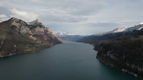 aerial pan above calm placid lake in walensee switzerland above steep cliffs