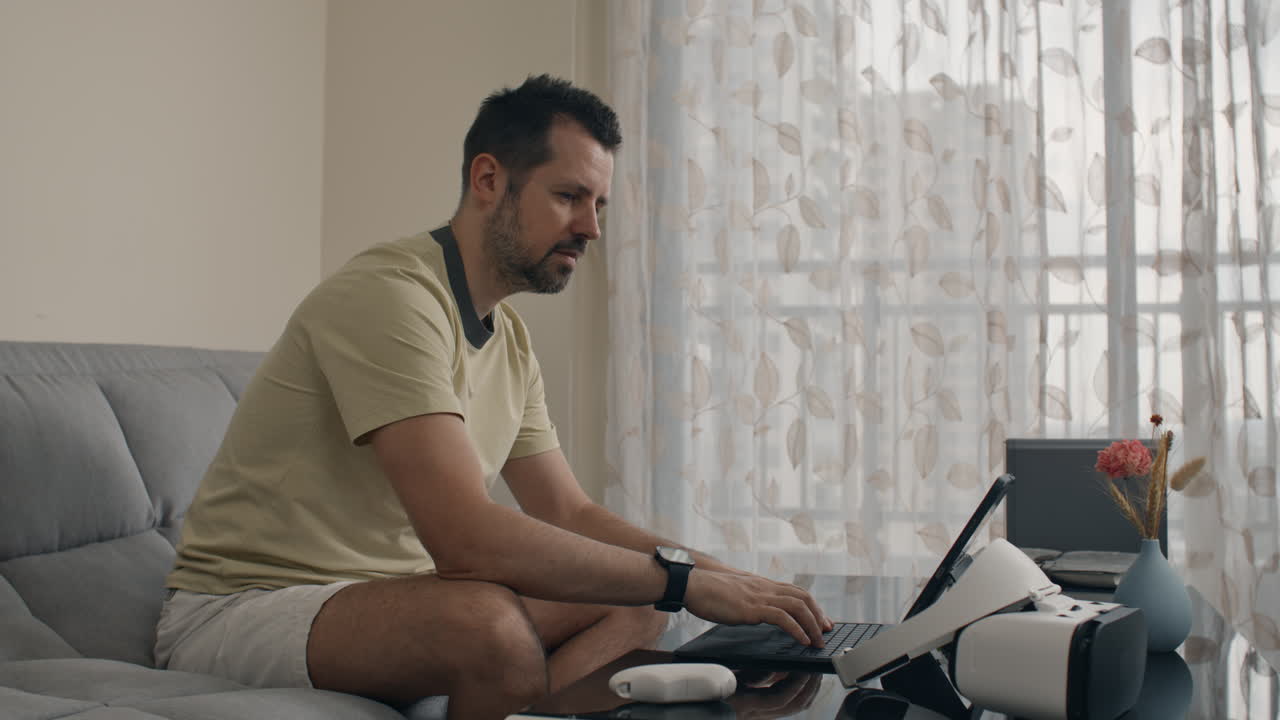 Man wearing VR headset and pointing in air navigating virtual menu at home