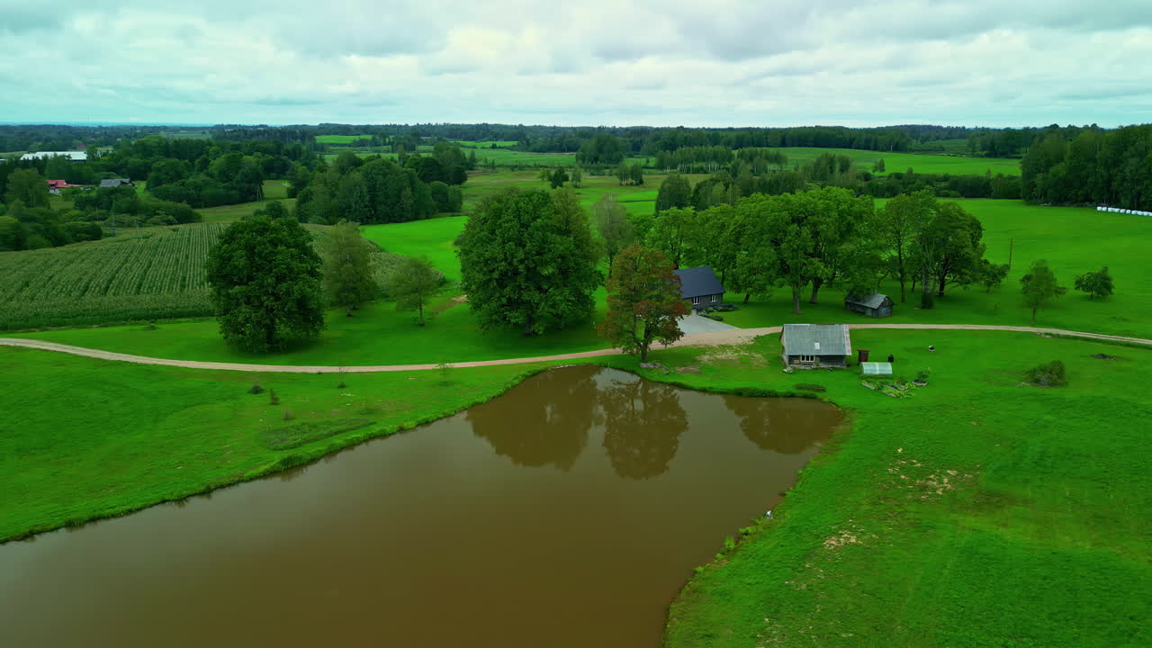 Campi verdi e stagno d'acqua sporca in un paesaggio di campagna, vista aerea.