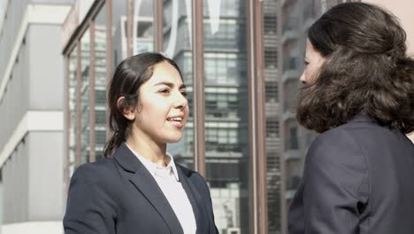 confident businesswomen talking on street