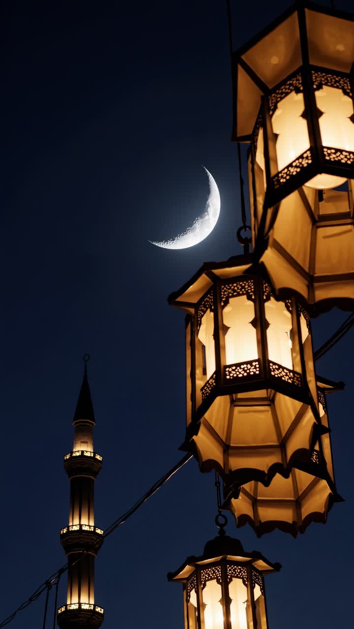 Vista dal basso di lanterne illuminate su una luna crescente e un minareto di notte