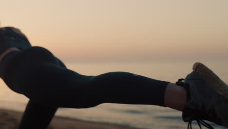 fit girl practicing yoga pose on beach. sporty woman training balance at dusk.