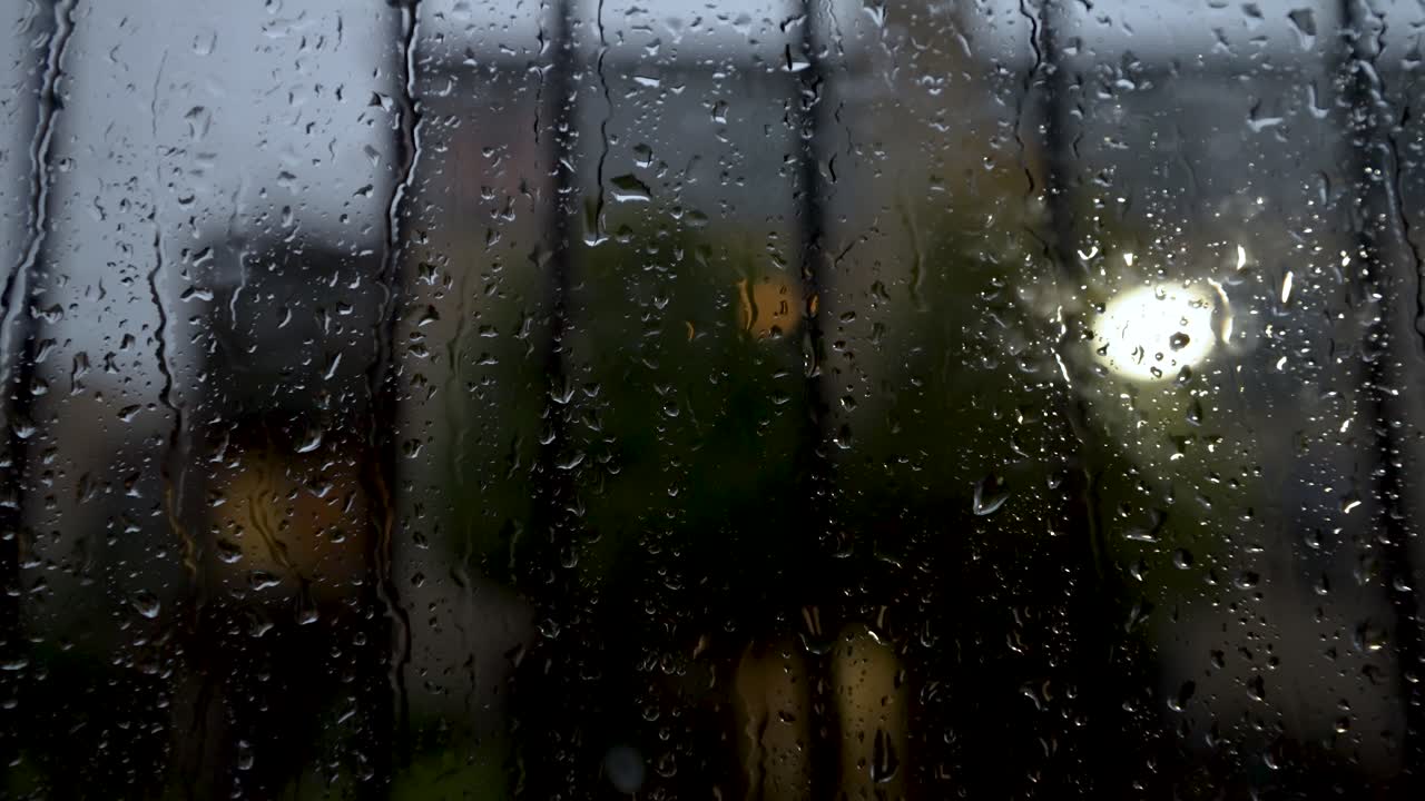 vista de cerca en la ventana cubierta de gotas de lluvia detrás de la barra de seguridad