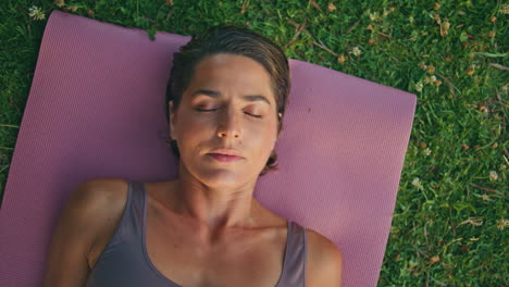 tranquil yogi woman laying mat meditating at green grass closeup. lady relaxing