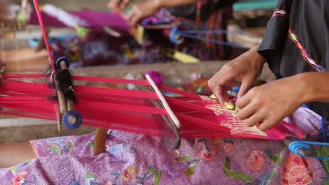 woman picking with a bobbin on a loom