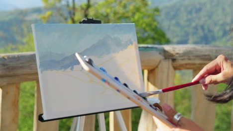 artista pintando un paisaje de montaña al aire libre