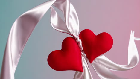 two red hearts tied with a white ribbon
