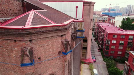 detailed view of supports and brackets for a brick structure in a deteriorated state and in danger of collapse, next to residential buildings