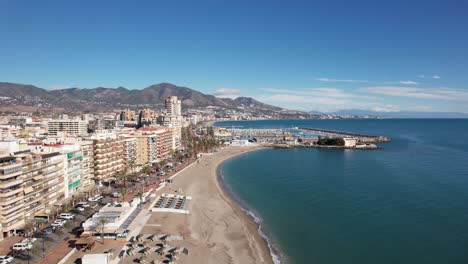 paisaje urbano por mar, orilla de la bahía de la playa con edificios, cielo azul de verano y montañas en la parte de atrás