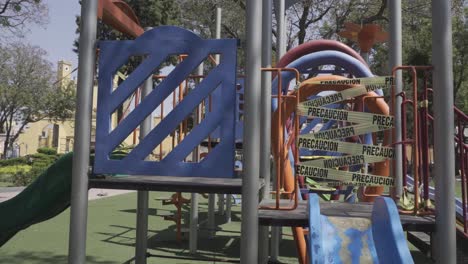 a closeup of a slide on a closed playground due to covid-19 pandemic