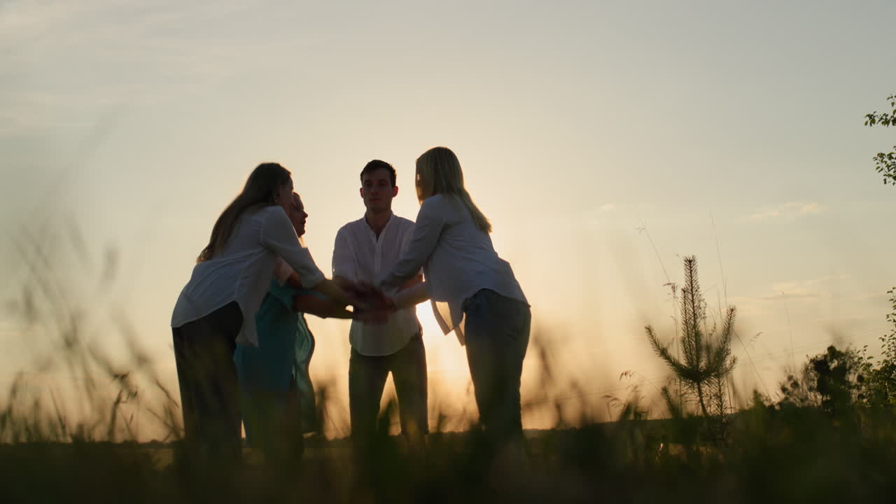 한 무리의 친구들이 손을 들어서 팀 성공과 팀워크 개념을 설명합니다.