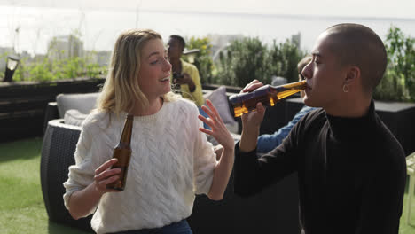 two friends drinking a beer and discussing on a rooftop