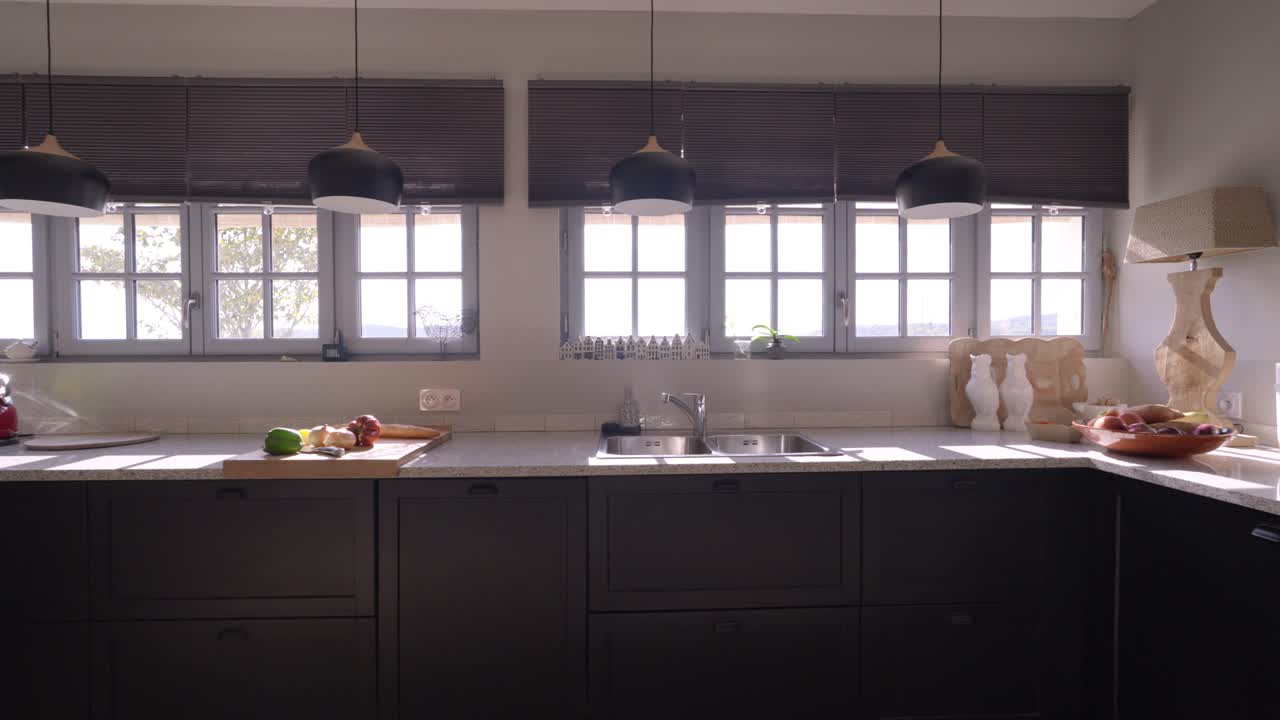 Inquadratura lenta d'ambiente di una cucina moderna con utensili e provviste sul piano di lavoro