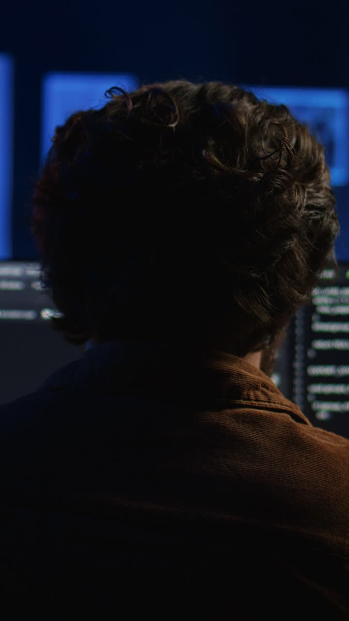 Man Working on Computer and Coding in a Dark Room at Night