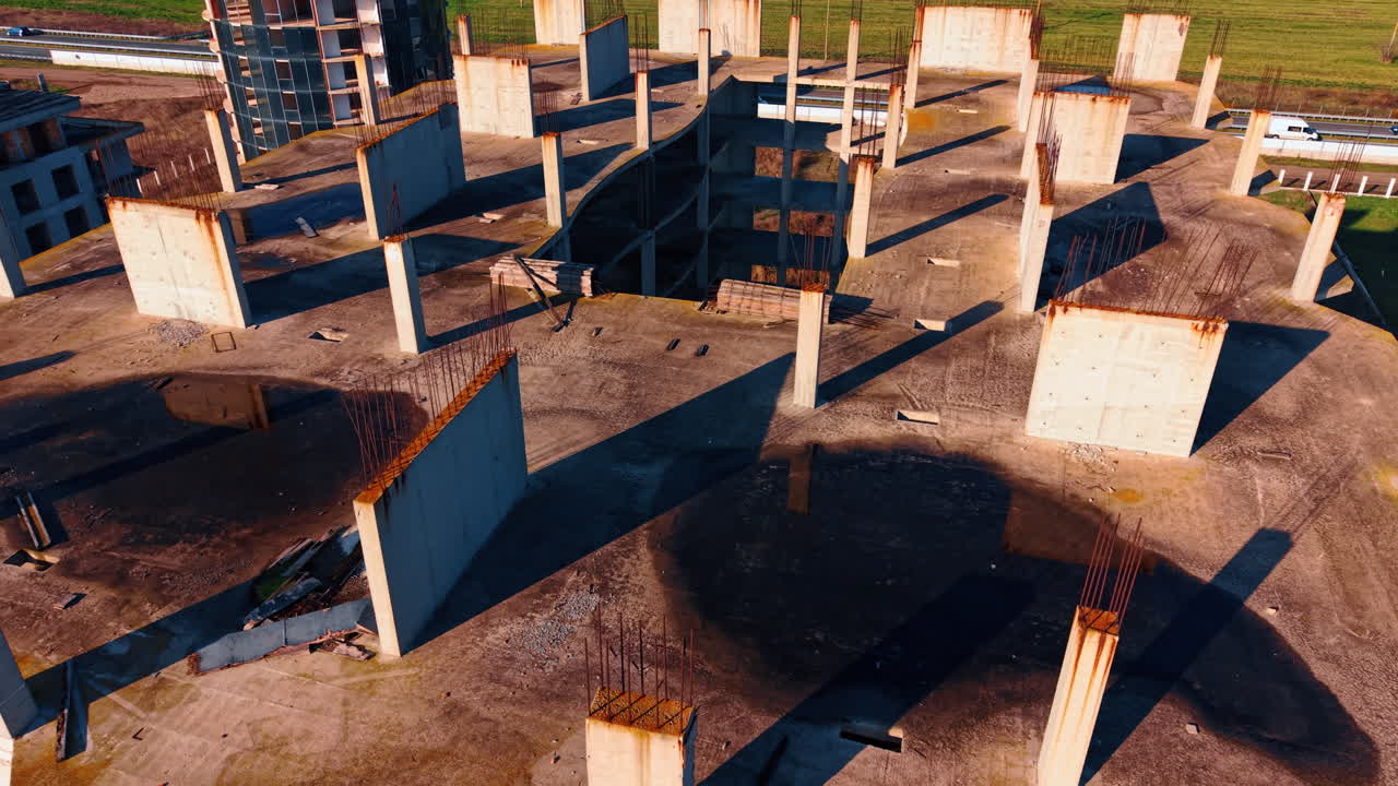 Vista aerea dall'alto della struttura in cemento di un edificio incompiuto. Vista con drone che guarda in basso sul tetto e sulle lastre di cemento di una grande struttura di edificio abbandonata
