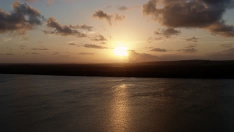 toma aérea de drones de una impresionante puesta de sol dorada desde el famoso destino turístico alligator beach en un gran río en cabedelo, paraiba, brasil, cerca de la capital costera de joao pessoa