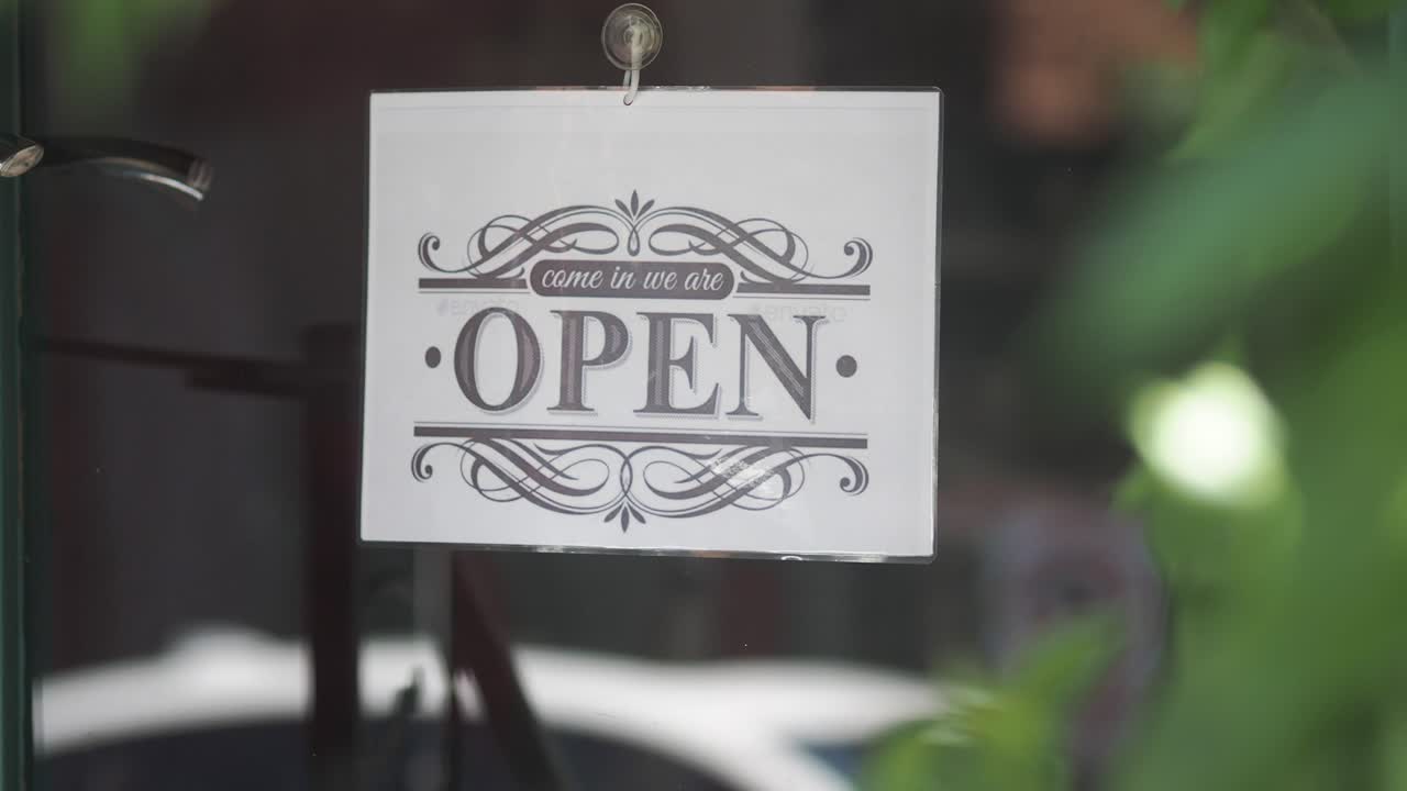 An 'Open' sign hanging in a store window