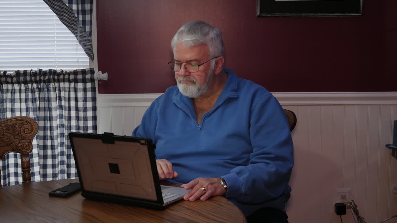 Senior Citizen Happy Using a Computer and Technology to do Daily Activities