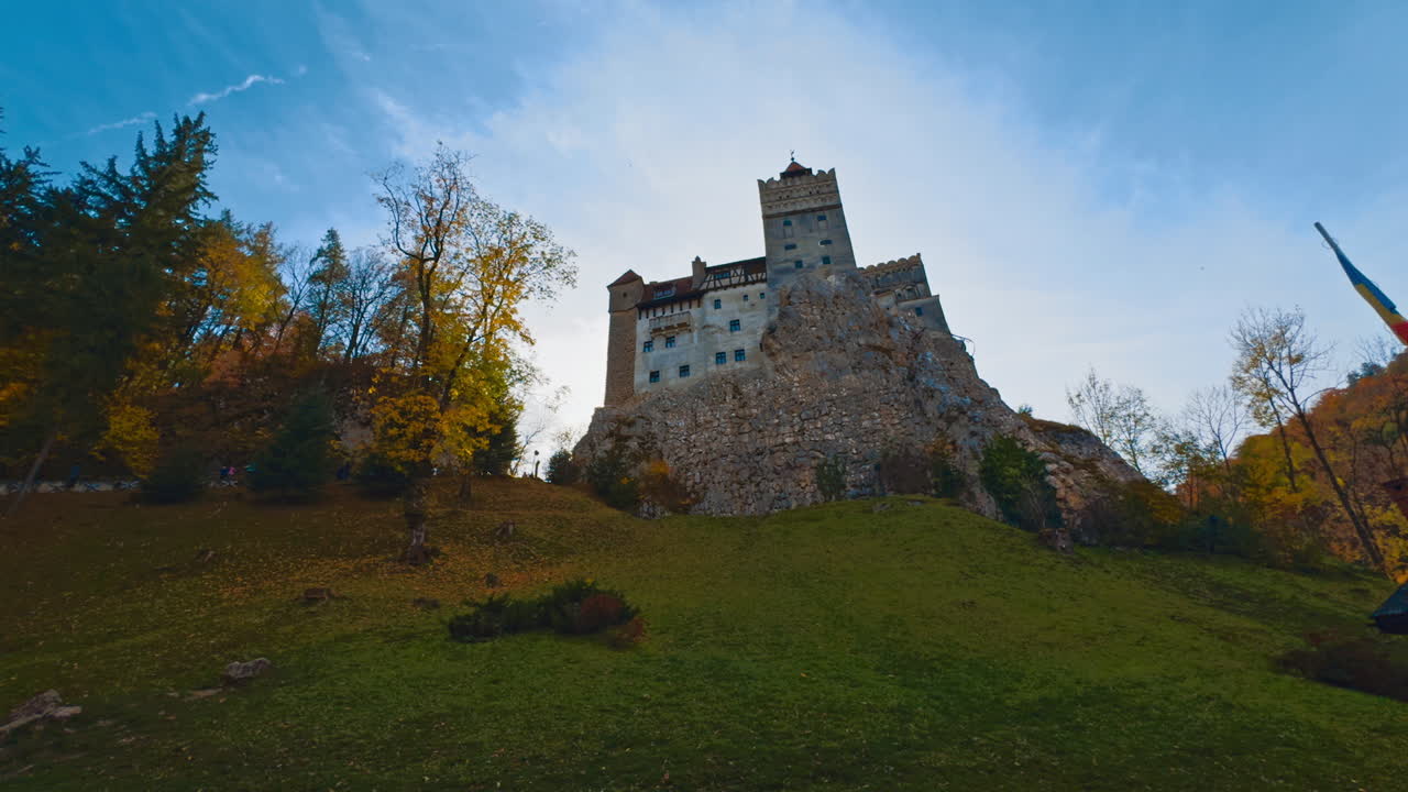 Sight of the beautiful medieval castle on the top of the hill. Romanian castle Bran of count Dracula in autumn season. Low angle view.