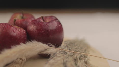 Manzana-Fresca-De-4k-Sobre-Una-Mesa-Girando-Sobre-Sí-Misma-Con-Luz-Cálida-Y-Fondo-Negro-En-Un-Ambiente-Oscuro-Interior-Con-Accesorios-Sencillos-Dispuestos-Uno-Al-Lado-Del-Otro