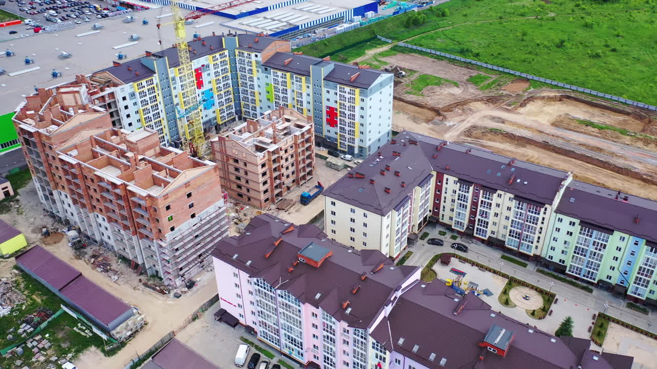 Construction of a new residential complex. Modern multi-storey buildings build in the city. Construction site with high cranes. Aerial view.