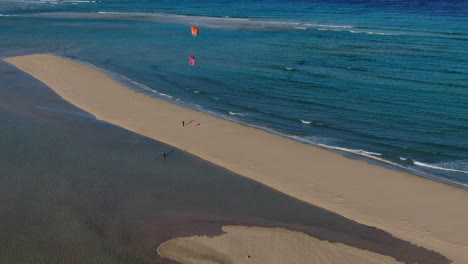 playa de la barca, fuerteventura: 은 날에 사람들이 카이트 서핑을 연습하는 아름다운 해변 위의 원형의 공중 풍경