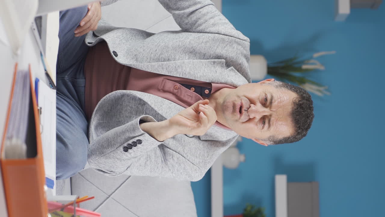 Vertical video of Home office worker old man talking facetime looking at camera.