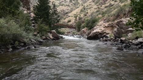 Flying-Above-River-Flowing-Through-Boulders-At-Clear-Creek-Canyon-Park-In-Colorado,-USA