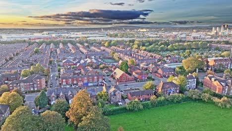 aerial tilt down of english neighborhood in manchester during sunset time , near old trafford stadium