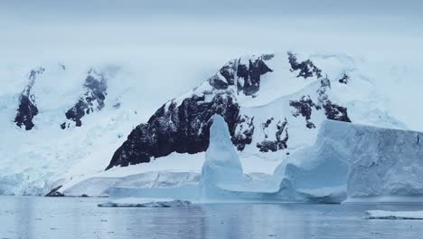 Global-Warming-and-Climate-Change-in-Antarctica-with-Mountains-and-Icebergs-Landscape-Scenery,-Ocean-and-Sea-Water-in-Beautiful-Dramatic-Amazing-Antarctic-Peninsula-Winter-Scene